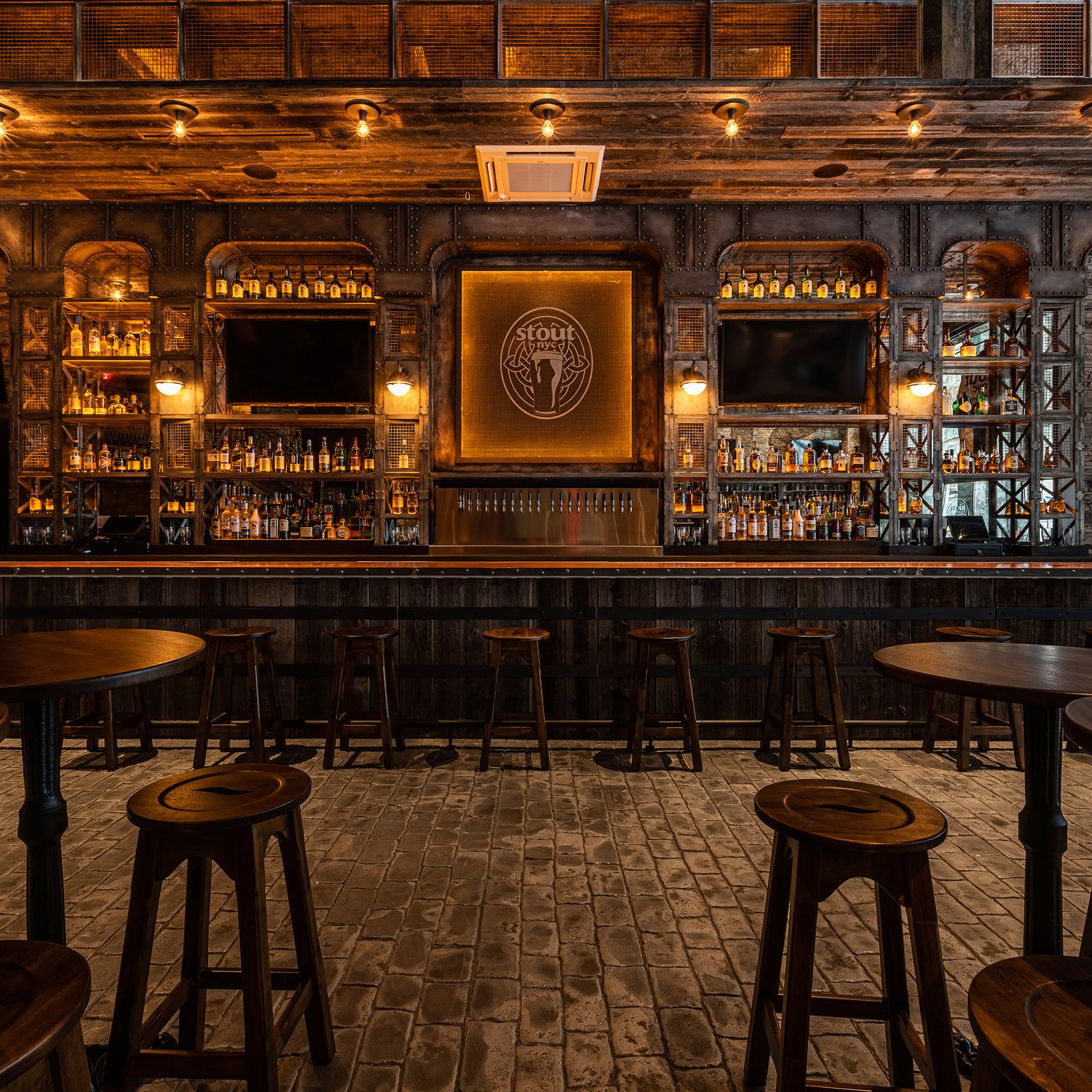 Bar interior with rich wood, warm pendant lighting, and intimate seating.